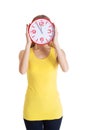 Casual caucasian woman holds clock on her face.