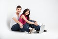 Casual couple sitting down with laptop Royalty Free Stock Photo