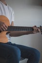 Casual day of a young singer who trains various guitar holdings and chords to improve his skills. Playing an instrumental