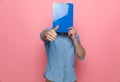 Casual denim guy covering face with clipboard Royalty Free Stock Photo