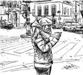 Casual girl in warm winter clothes stands in city on street at intersection and uses smartphone. Cityscape