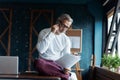 Casual Grey-haired Mature businessman talking on a mobile phone standing by the window. Royalty Free Stock Photo