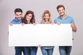 Casual group of young people holding a big blank board Royalty Free Stock Photo