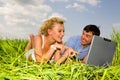 Casual happy couple on a laptop computer outdoors