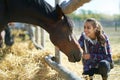 Casual happy woman petting horse on countryside farm or ranch Royalty Free Stock Photo