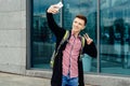 Casual happy young man in plaid shirt with backpack walking Royalty Free Stock Photo