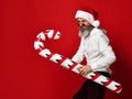 Excited brutal man in santa hat with candy cane