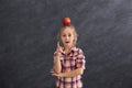 Casual little girl showing finger up at gray background Royalty Free Stock Photo