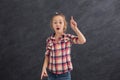 Casual little girl showing finger up at gray background Royalty Free Stock Photo