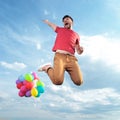 Casual man with balloons jumps in the air Royalty Free Stock Photo