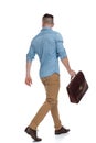 Casual man with briefcase walking one direction looking another Royalty Free Stock Photo