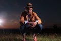 Casual man crouched in the grass Royalty Free Stock Photo