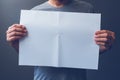 Casual man holding blank A3 paper spread as copy space Royalty Free Stock Photo