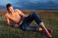 Casual man looks away while laying in grass Royalty Free Stock Photo