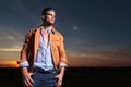 Casual man looks away with thumbs in pockets at sunset Royalty Free Stock Photo