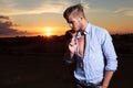 Casual man looks down with sunset behind Royalty Free Stock Photo