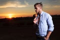 Casual man looks to his side with sunset behind