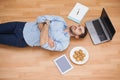 Casual man lying on floor surrounded by his possesions Royalty Free Stock Photo