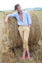 Casual man outdoor with hand in pocket and on haystack Royalty Free Stock Photo