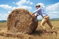 Casual man outdoor pushing a haystack Royalty Free Stock Photo