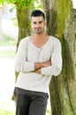 Casual man outdoors leaning on a tree Royalty Free Stock Photo