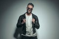 Casual man pulling his leather jacket, wearing sunglasses Royalty Free Stock Photo