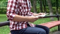 Casual man reading newspaper in park, spending leisure time, carefree weekend