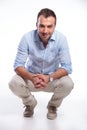 Casual man sitting crouched and smiling Royalty Free Stock Photo
