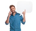 Casual man talking on the phone and holding speech bubble Royalty Free Stock Photo