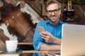 Casual man texting a message on phone looking at camera Royalty Free Stock Photo