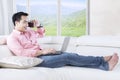 Casual man uses laptop on couch Royalty Free Stock Photo