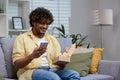 Casual man using phone and holding box at home Royalty Free Stock Photo