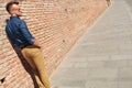 Casual man by wall with hands in pockets Royalty Free Stock Photo