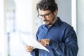 Casual man wearing glasses  reading paper document or contract. Royalty Free Stock Photo