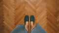Casual man wearing home slippers standing in bedroom on oak parquet flooring, top view Royalty Free Stock Photo