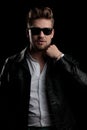 Casual man wearing sunglasses standing and fixing his collar Royalty Free Stock Photo