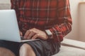 Casual man working from home on laptop computer while sitting at living room sofa Royalty Free Stock Photo