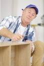 casual mature man assembling furniture in new house Royalty Free Stock Photo