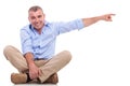 Casual middle aged man sits and points Royalty Free Stock Photo