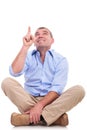 Casual middle aged man sits and points up Royalty Free Stock Photo