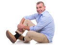 Casual middle aged man sits and smiles at you Royalty Free Stock Photo