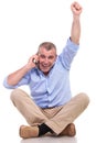 Casual old man sits and cheers while on phone Royalty Free Stock Photo