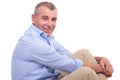 Casual old man sits and smiles at you Royalty Free Stock Photo