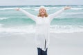 Casual senior woman with arms outstretched at beach Royalty Free Stock Photo