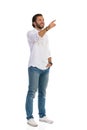 Casual Smiling Man Is Standing With Hand In Pocket, Looking Up And Pointing Royalty Free Stock Photo