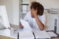 Casual stressed businessman going over paperwork at his desk