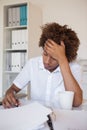 Casual stressed businessman writing at his desk Royalty Free Stock Photo