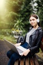 Casual student listening to music on the computer while studying in campus park Royalty Free Stock Photo