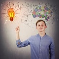 Casual teen boy pointing his index finger up showing a bright light bulb on the wall. Idea concept, positive thinking as colorful Royalty Free Stock Photo