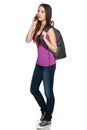 Casual teen girl wearing backpack talking on cell phone Royalty Free Stock Photo